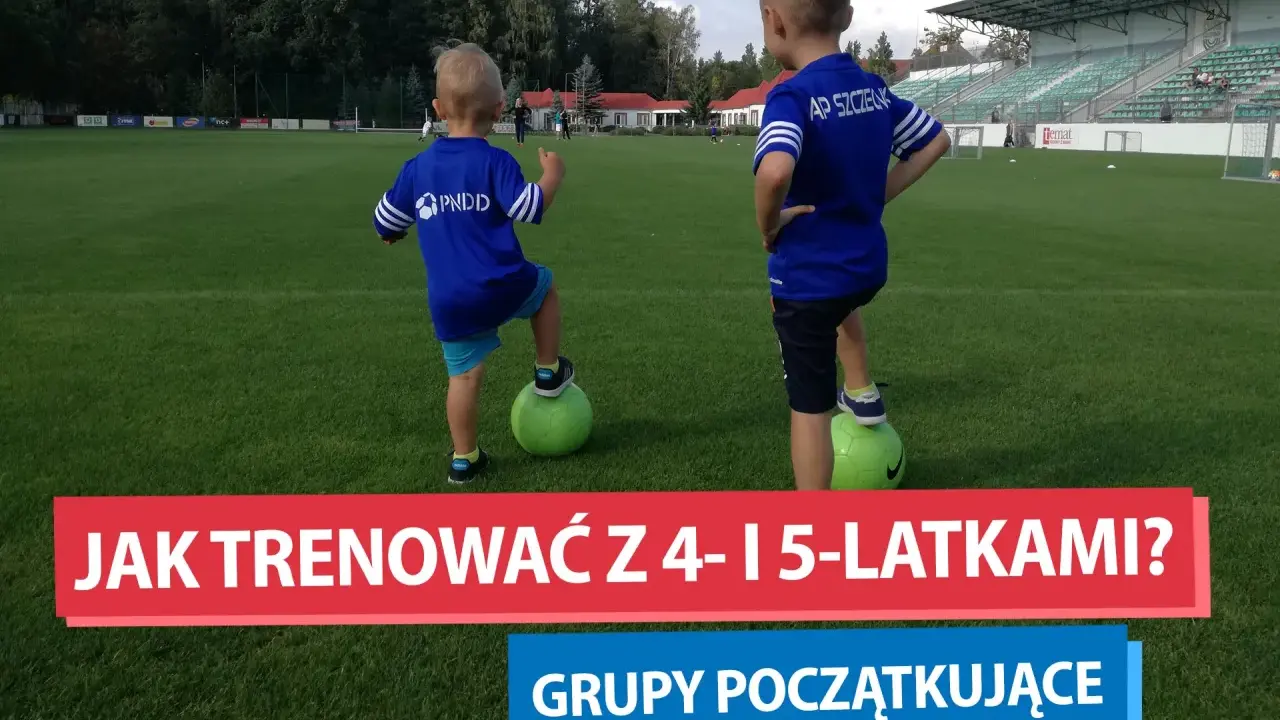 Dwóch chłopców na boisku piłkarskim, każdy z nogą na zielonej piłce. To początek ich treningu piłkarskiego dla dzieci 4-6 lat.