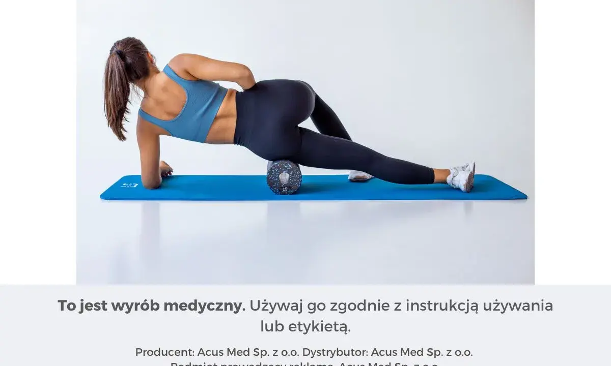 Kobieta na macie rehabilitacyjnej używa wałka do masażu mięśni, aby rozluźnić uda.