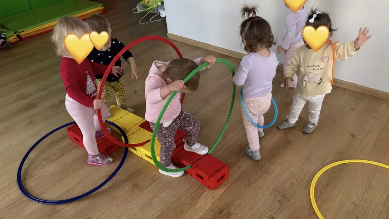 Dzieci bawią się kolorowymi hula hop na sali gimnastycznej. Radość i ruch to najlepsze zabawy z hula hop!