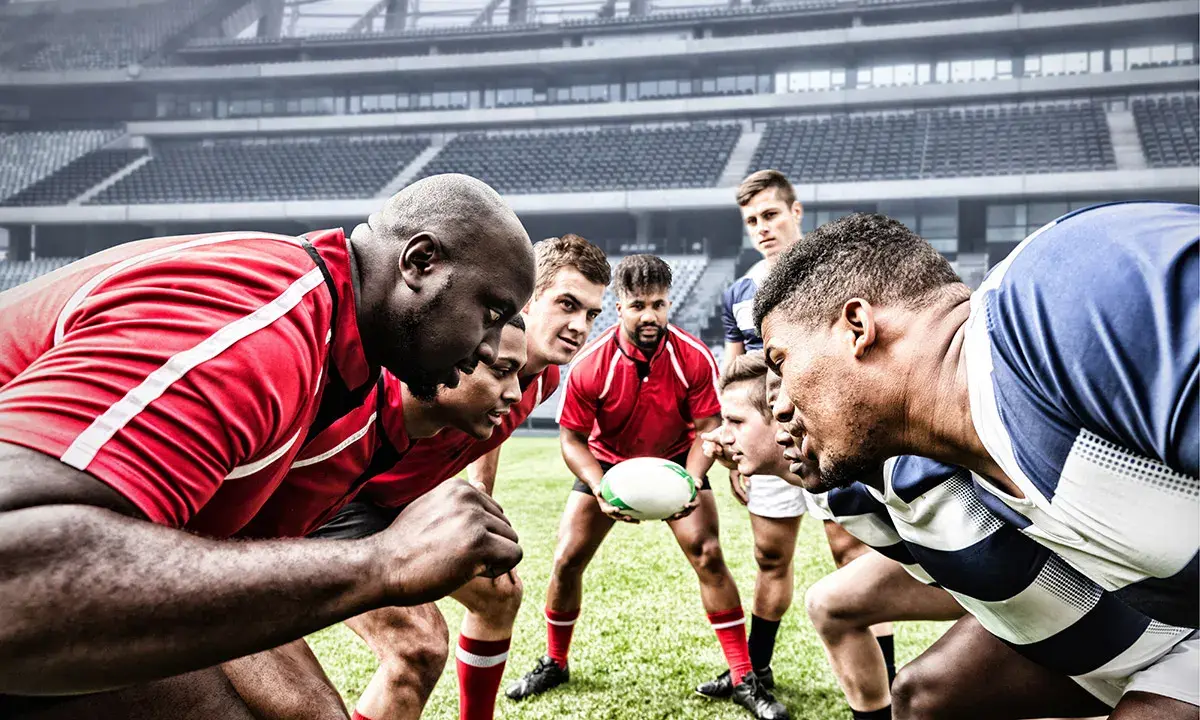 Zawodnicy rugby i futbolu amerykańskiego w skupieniu przed meczem na stadionie.