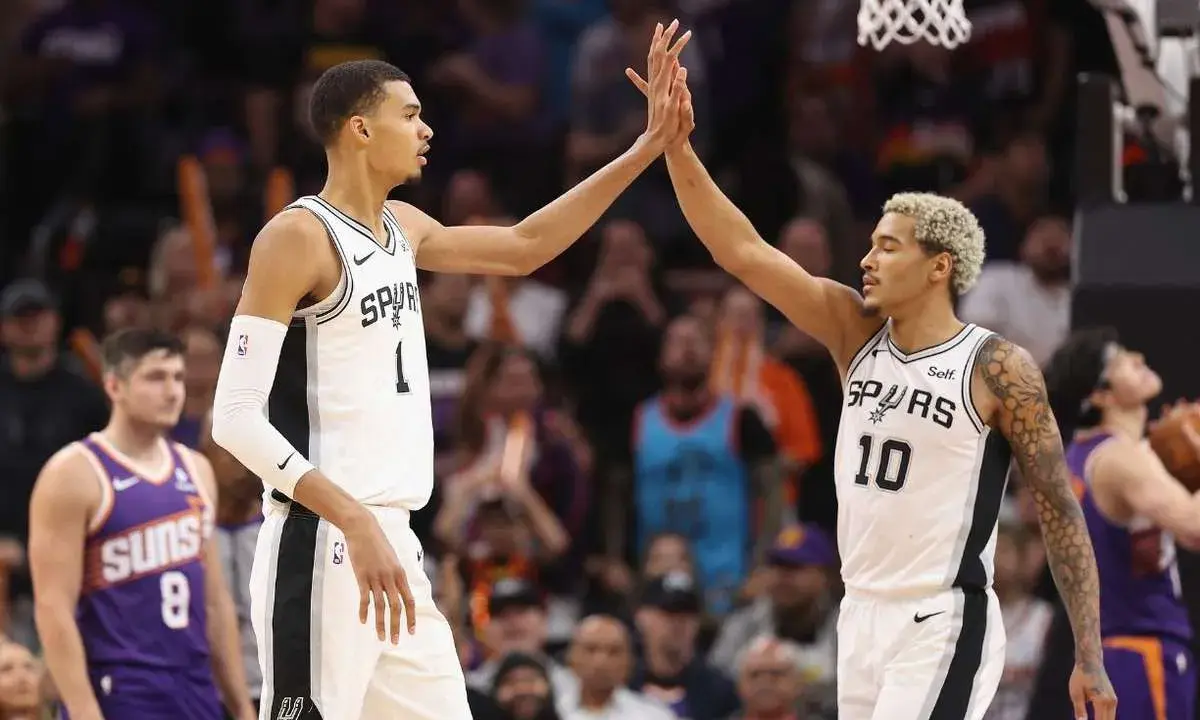 Dwóch koszykarzy San Antonio Spurs świętuje udaną akcję, która zakończyła się asystą w koszykówce.