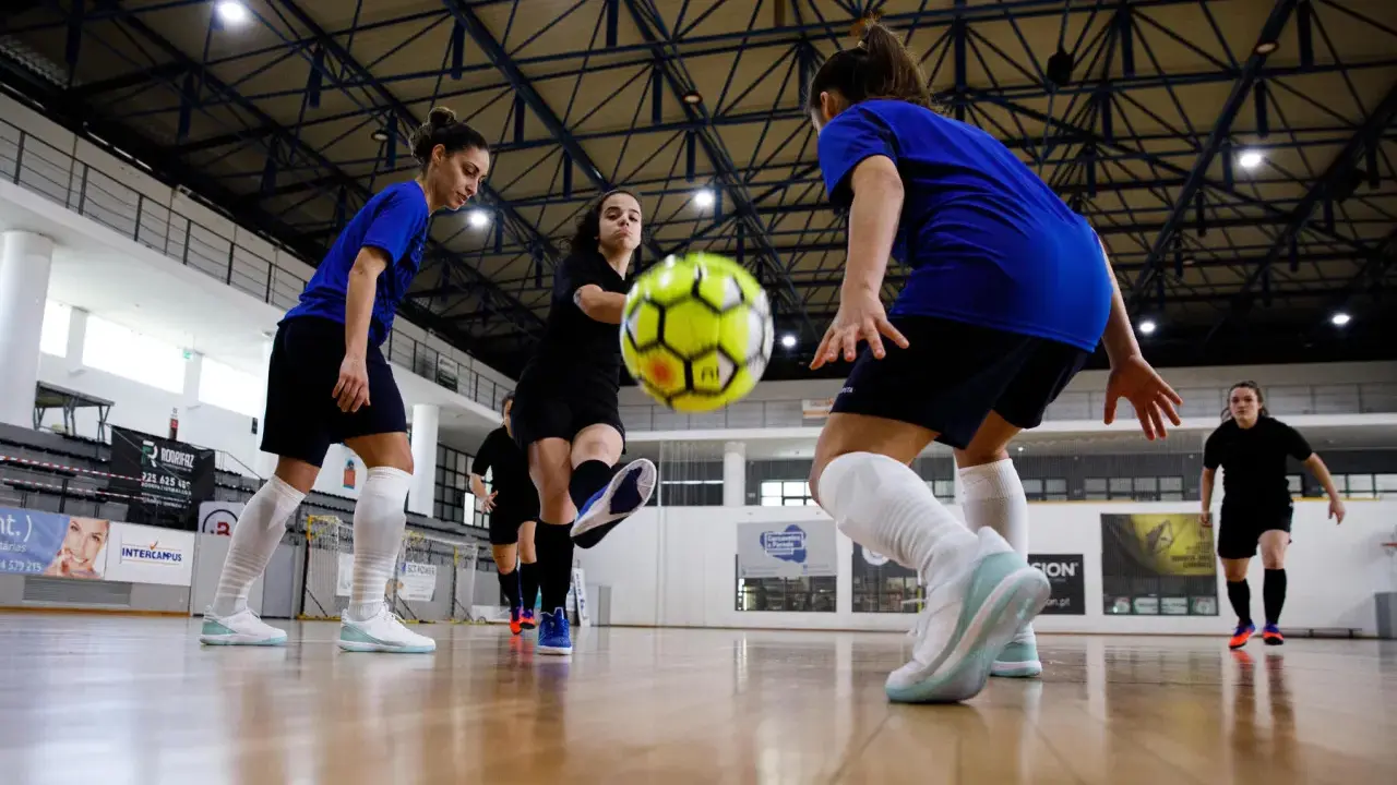 Piłkarki walczą o piłkę na hali. Zastanawiasz się, ile trwa mecz futsalu? To dynamiczna gra, która wymaga szybkości i precyzji.