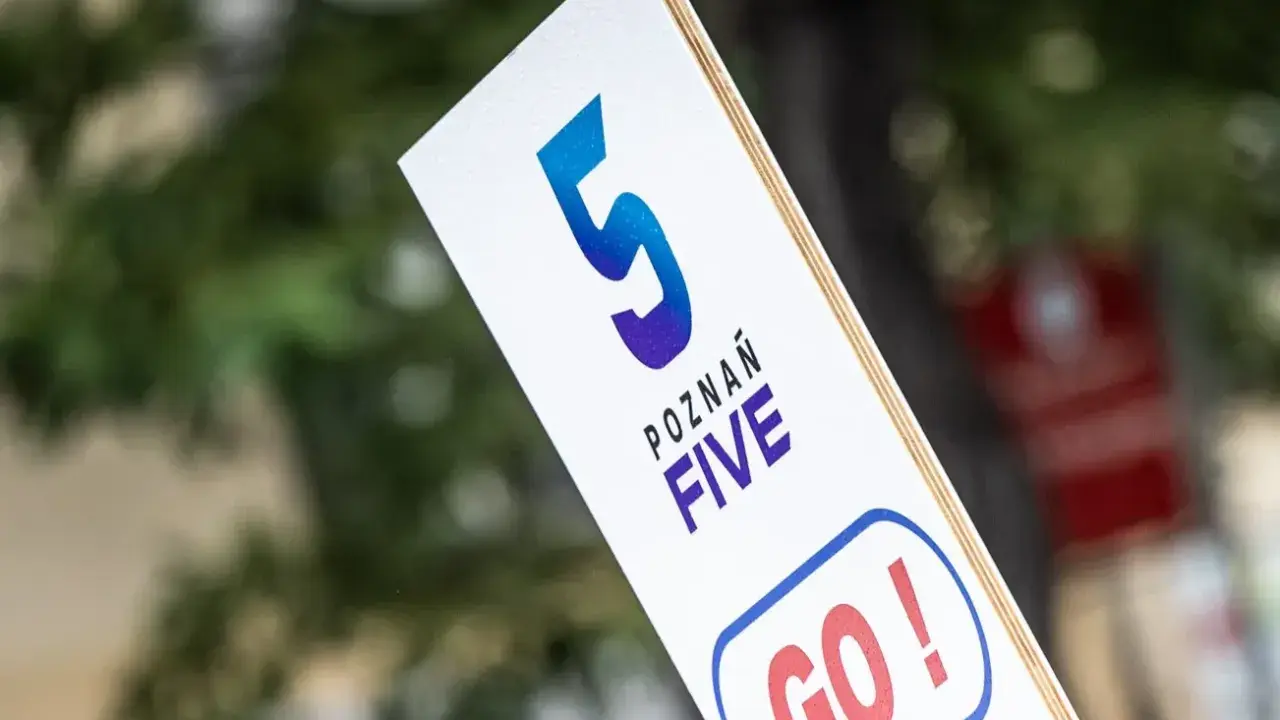 Tabliczka z napisem "POZNAŃ FIVE GO!" zachęca do biegu na 5 km.