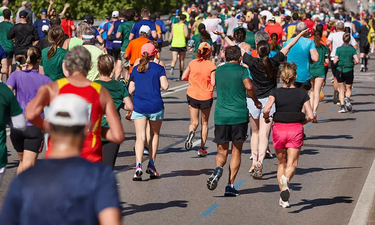 Tłum biegaczy pokonuje trasę maratonu. Czy wiesz, ile km ma maraton? To aż 42,195 km!