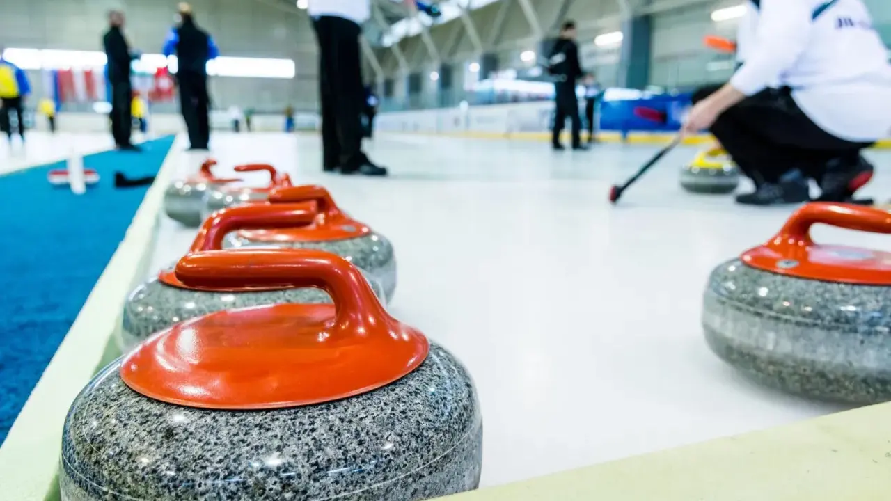 Kamienie do curlingu, każdy ważący ok. 20 kg, czekają na lodzie.