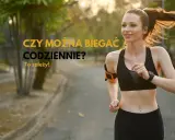 Uśmiechnięta biegaczka w sportowym stroju zastanawia się, czy można biegać codziennie. To zależy od wielu czynników, ale jej entuzjazm jest zaraźliwy.