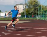 Młody biegacz na bieżni podczas zajęć sportowych dla młodzieży.