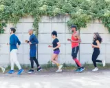 Grupa ludzi w sportowych strojach bierze udział w zabawie biegowej.