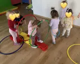 Dzieci bawią się kolorowymi hula hop na sali gimnastycznej. Radość i ruch to najlepsze zabawy z hula hop!