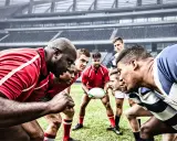 Zawodnicy rugby i futbolu amerykańskiego w skupieniu przed meczem na stadionie.