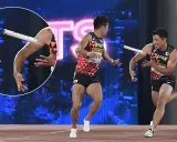Dwóch lekkoatletów z Japonii w trakcie biegu z pałeczką. Jeden z nich biegnie, drugi wyciąga rękę po pałeczkę.