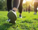 Ludzie uprawiający power walking na trawie w parku, w promieniach słońca.