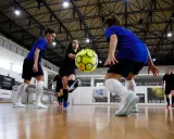 Piłkarki walczą o piłkę na hali. Zastanawiasz się, ile trwa mecz futsalu? To dynamiczna gra, która wymaga szybkości i precyzji.