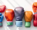 Kolorowe rękawice do kickboxingu ułożone obok siebie. Różowy, niebieski, pomarańczowy, fioletowy, żółty i czerwony sprzęt treningowy.