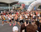 Uczestnicy maratonu w Warszawie, gotowi do startu. To świetny przykład, jak przygotować się do maratonu: trening, determinacja i wsparcie kibiców.