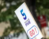 Tabliczka z napisem "POZNAŃ FIVE GO!" zachęca do biegu na 5 km.
