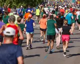 Tłum biegaczy pokonuje trasę maratonu. Czy wiesz, ile km ma maraton? To aż 42,195 km!