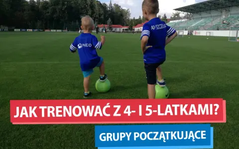 Dwóch chłopców na boisku piłkarskim, każdy z nogą na zielonej piłce. To początek ich treningu piłkarskiego dla dzieci 4-6 lat.