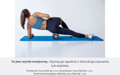 Kobieta na macie rehabilitacyjnej używa wałka do masażu mięśni, aby rozluźnić uda.