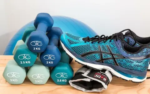 Idealne **jakie buty na siłownię**? Turkusowe Asicsy i zestaw hantli od 2 do 3 kg, gotowe do treningu.