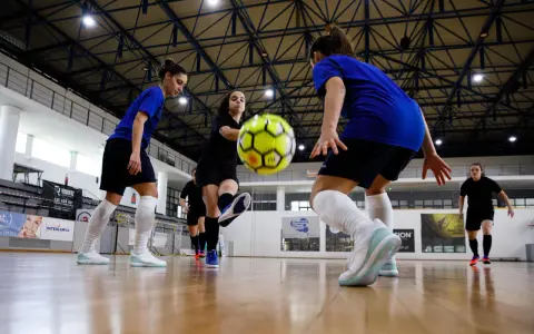 Piłkarki walczą o piłkę na hali. Zastanawiasz się, ile trwa mecz futsalu? To dynamiczna gra, która wymaga szybkości i precyzji.