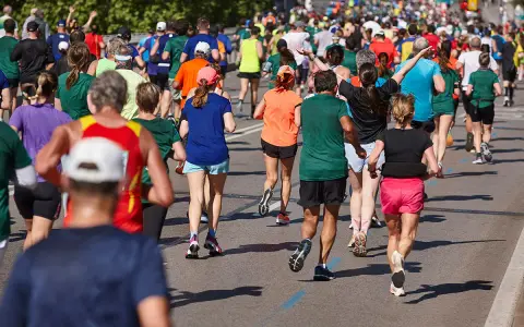 Tłum biegaczy pokonuje trasę maratonu. Czy wiesz, ile km ma maraton? To aż 42,195 km!