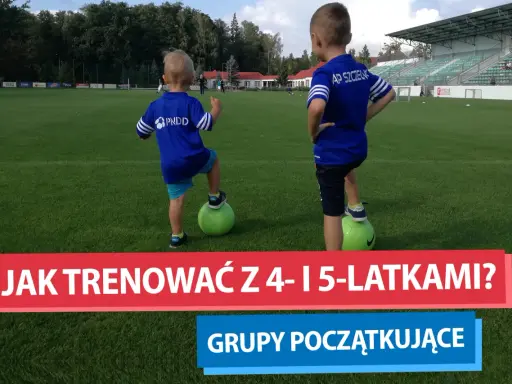 Dwóch chłopców na boisku piłkarskim, każdy z nogą na zielonej piłce. To początek ich treningu piłkarskiego dla dzieci 4-6 lat.