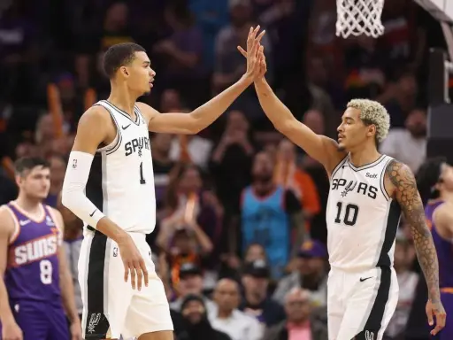Dwóch koszykarzy San Antonio Spurs świętuje udaną akcję, która zakończyła się asystą w koszykówce.