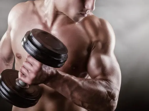 Mężczyzna podnosi ciężarek, jego napięty biceps jest wyraźnie widoczny.