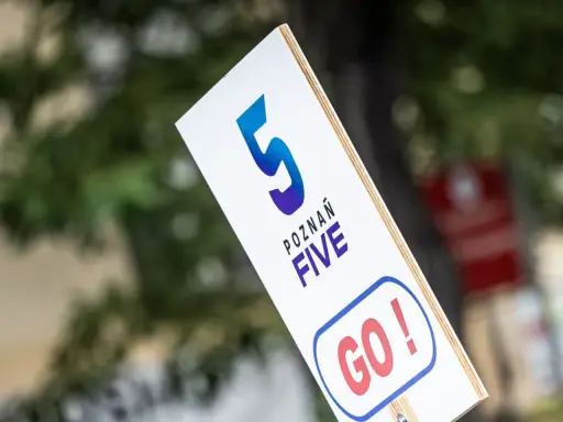 Tabliczka z napisem "POZNAŃ FIVE GO!" zachęca do biegu na 5 km.