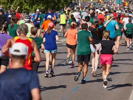 Tłum biegaczy pokonuje trasę maratonu. Czy wiesz, ile km ma maraton? To aż 42,195 km!