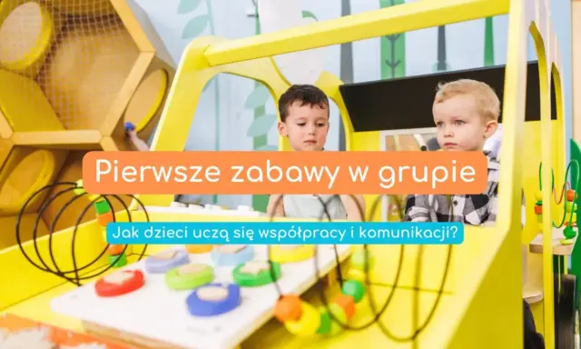 Dwóch chłopców bawi się w żółtym pojeździe. Pierwsze zabawy w grupie uczą współpracy i komunikacji.