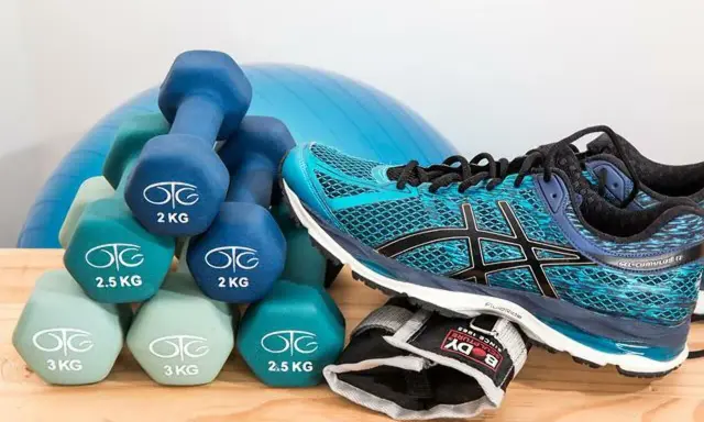Idealne **jakie buty na siłownię**? Turkusowe Asicsy i zestaw hantli od 2 do 3 kg, gotowe do treningu.
