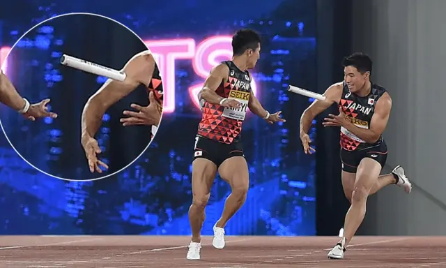 Dwóch lekkoatletów z Japonii w trakcie biegu z pałeczką. Jeden z nich biegnie, drugi wyciąga rękę po pałeczkę.
