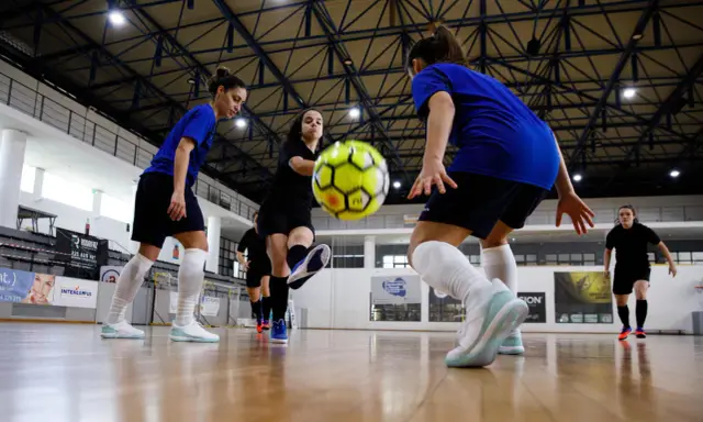 Piłkarki walczą o piłkę na hali. Zastanawiasz się, ile trwa mecz futsalu? To dynamiczna gra, która wymaga szybkości i precyzji.