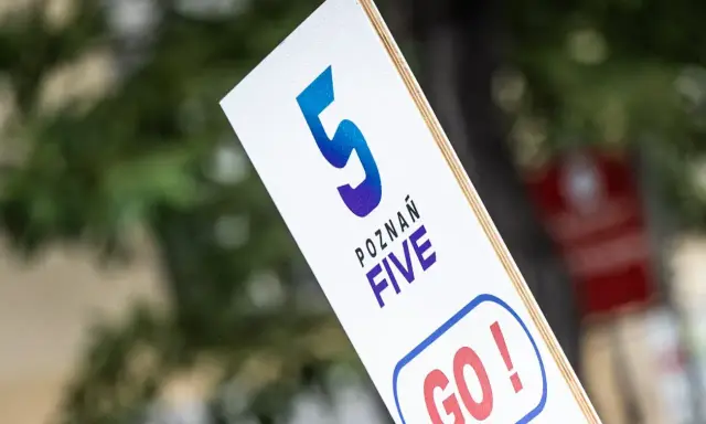 Tabliczka z napisem "POZNAŃ FIVE GO!" zachęca do biegu na 5 km.