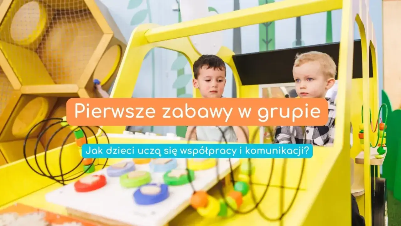 Dwóch chłopców bawi się w żółtym pojeździe. Pierwsze zabawy w grupie uczą współpracy i komunikacji.