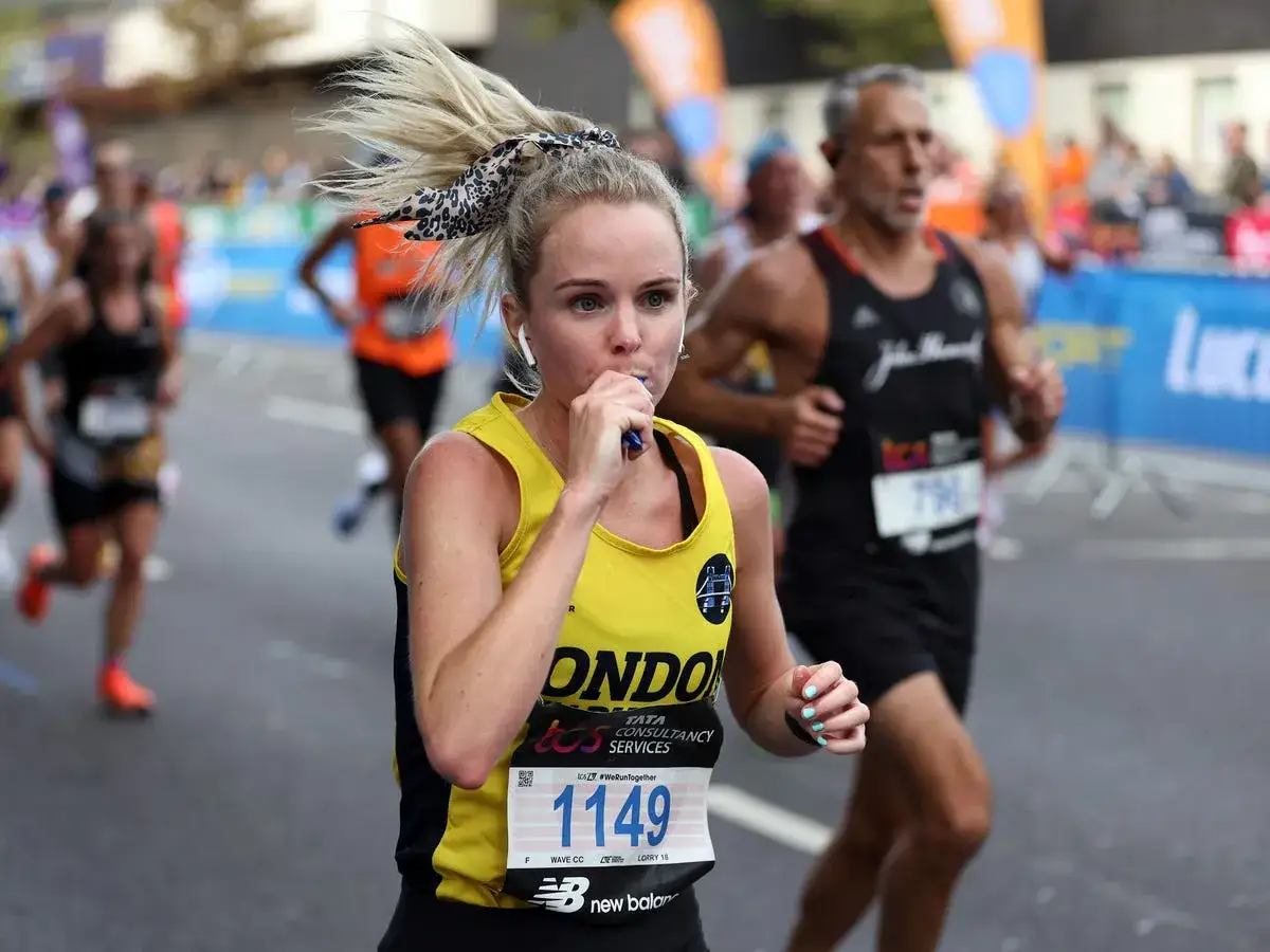 Biegaczka w żółtej koszulce z numerem 1149 pije podczas maratonu. Czy wiesz, ile km ma maraton?